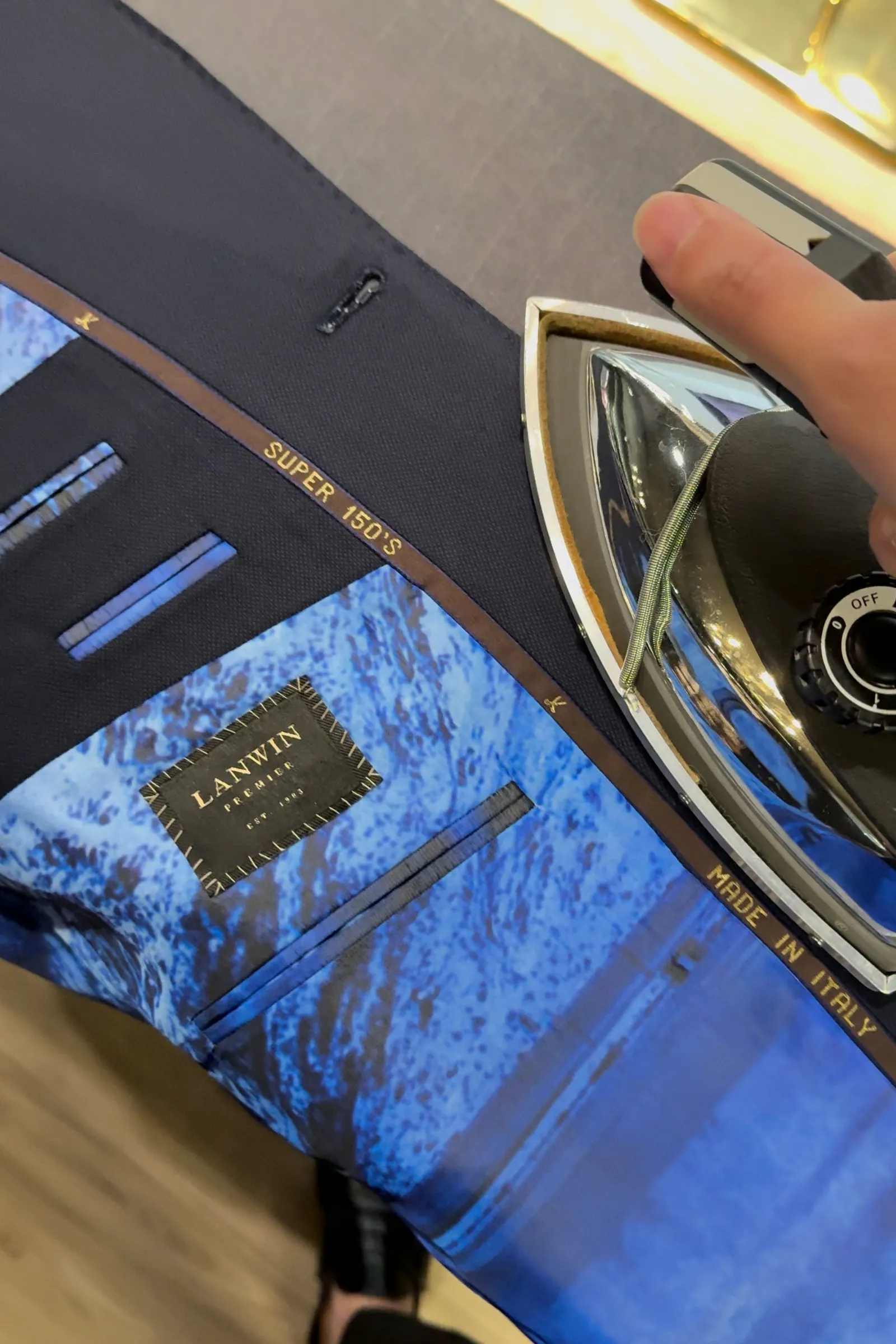 Hand pressing a finished LANWIN jacket with an iron before collection
